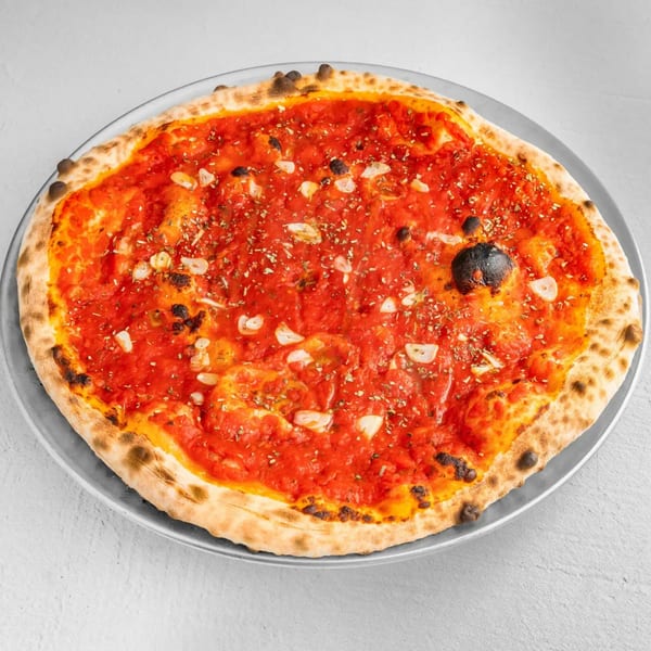 How Ya Dough'n Pizza's marinara pizza, topped with garlic and oregano, on a metal tray.
